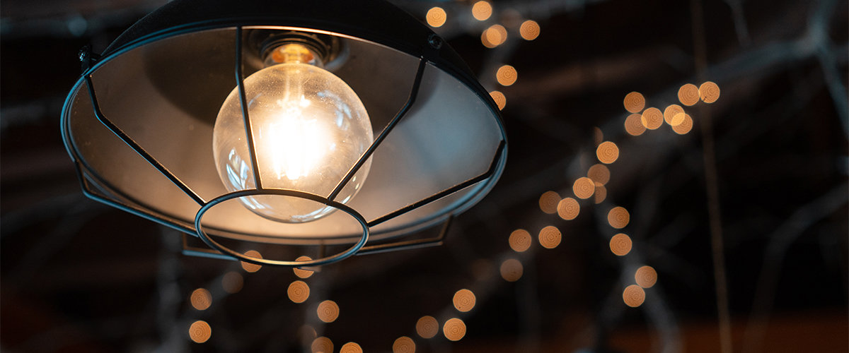 Overhead deck light with string lights in background